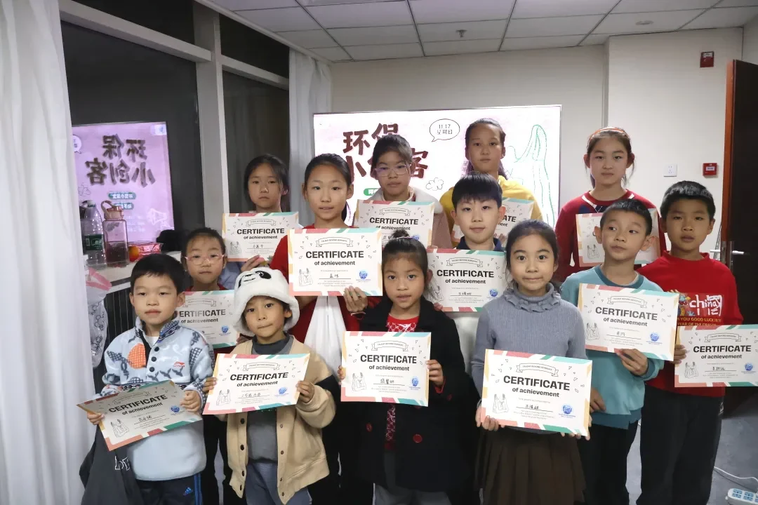 环保小创客活动成果合影，孩子们展示旧衣改造证书